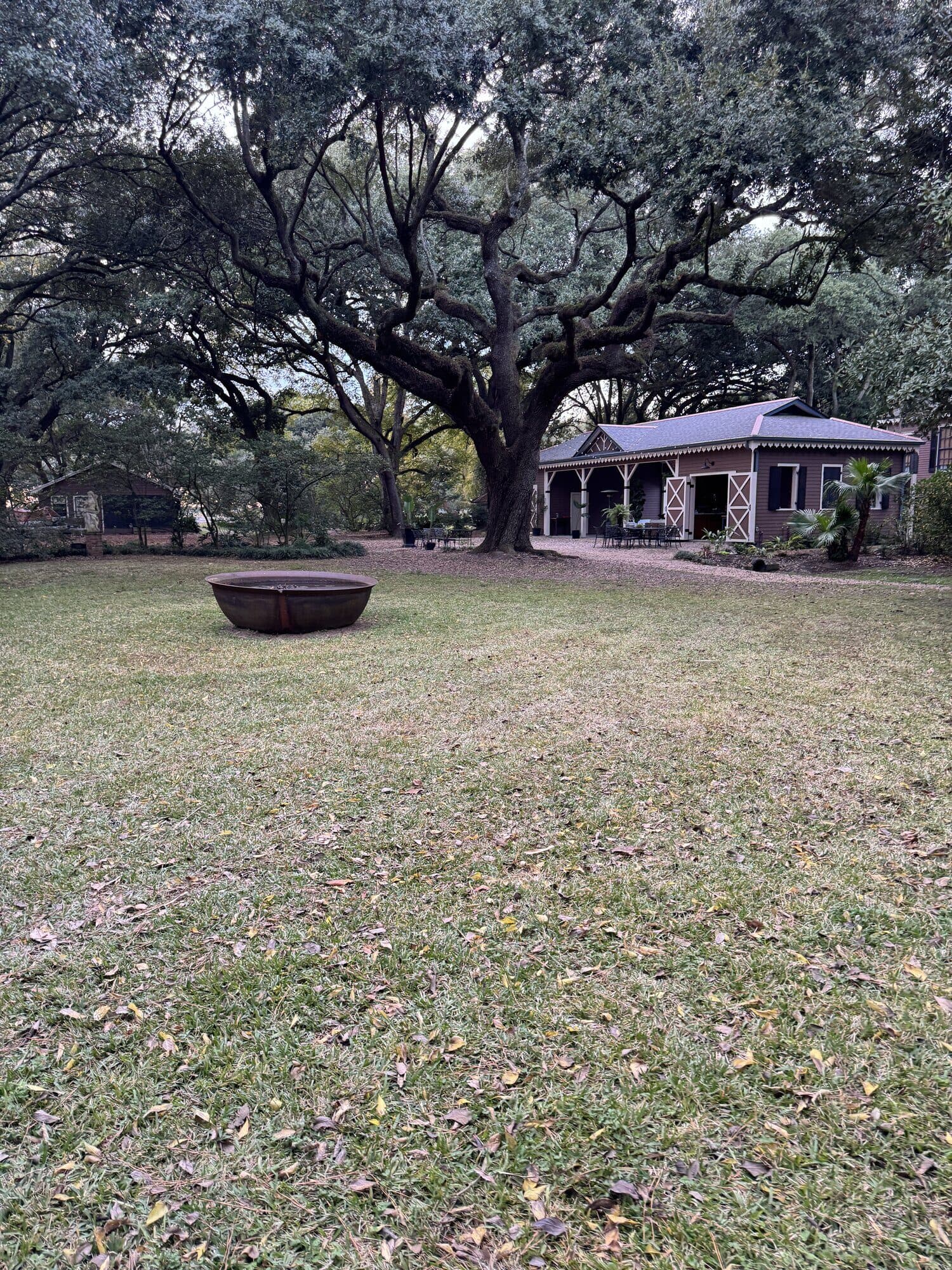 The carriage house pavilion on the Poplar Grove grounds, shaded by mature oaks.