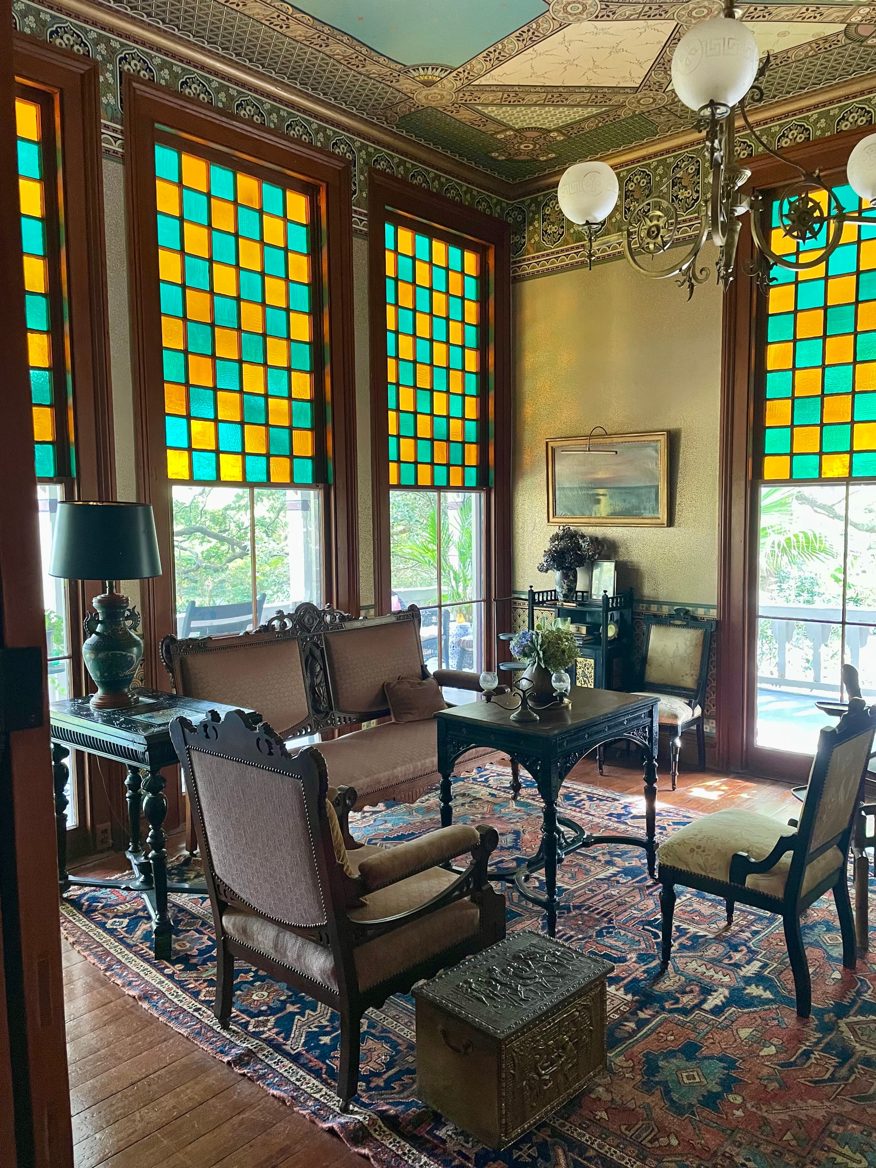 The front parlor at Poplar Grove — Bradbury & Bradbury wallpaper on the ceiling and frieze, with the original 1884 stained glass windows.